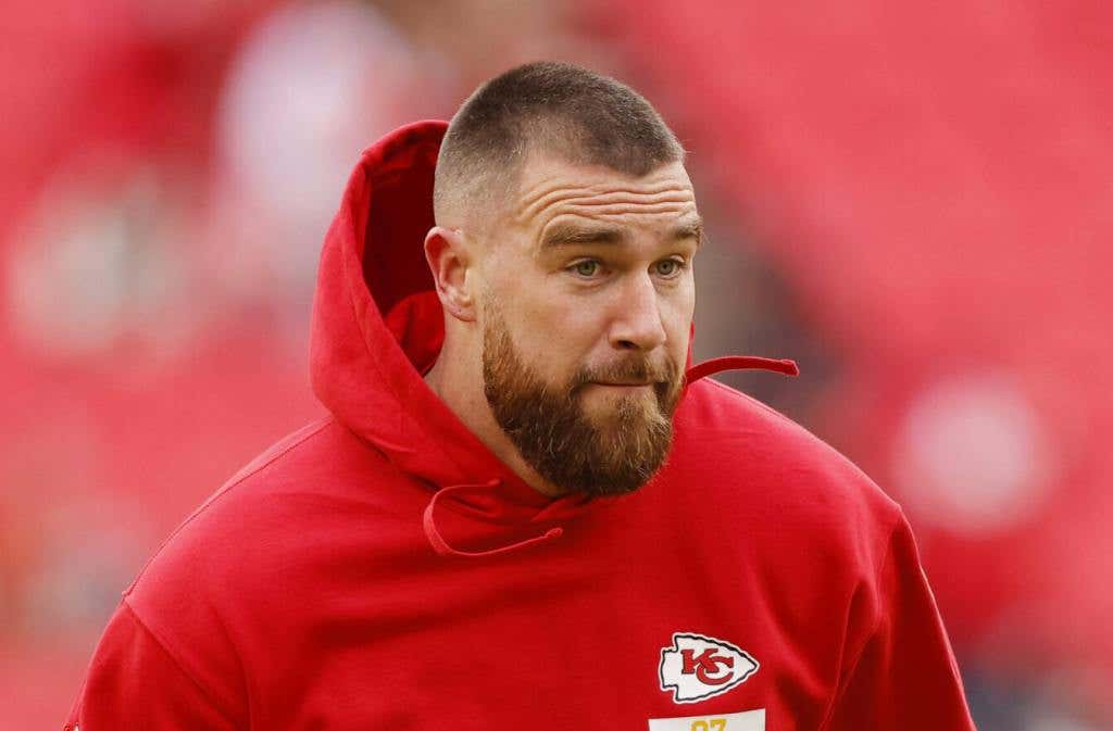 Travis Kelce #87 of the Kansas City Chiefs warms up before the game against the Cincinnati Bengals at GEHA Field wearing a red hoodie.