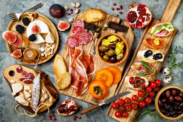 Appetizers table with italian antipasti snacks. Brushetta or authentic traditional spanish tapas set, cheese variety board over grey concrete background. Top view, easy Christmas appetizers