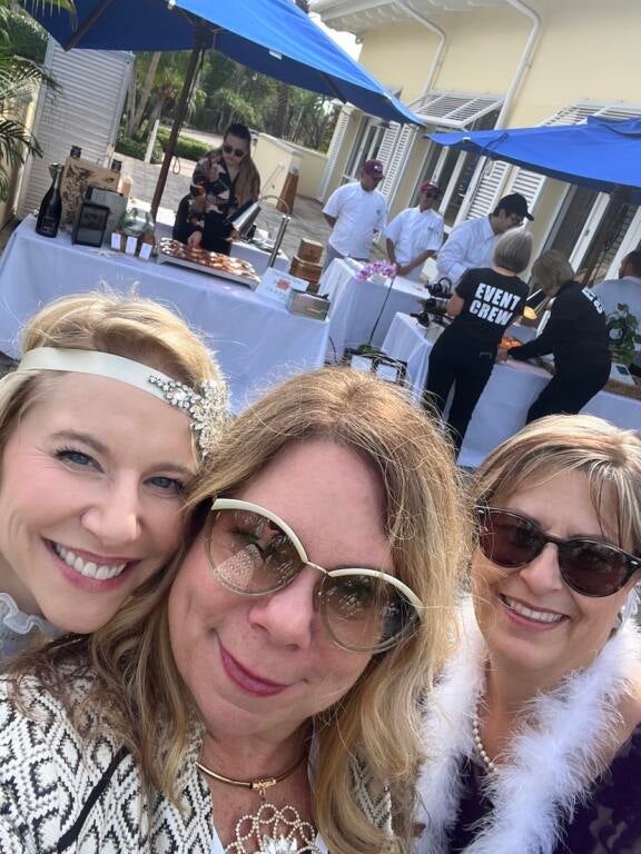 Three ladies smiling at the camera outside