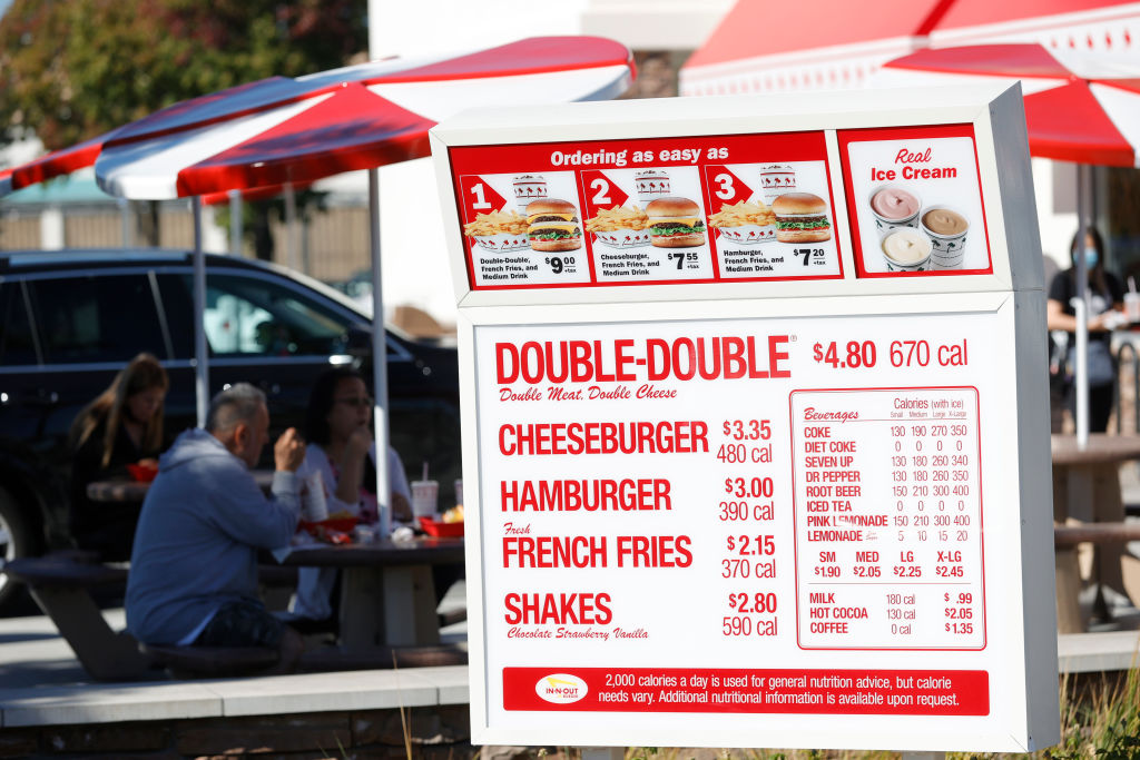 A menu is displayed in the drive thru at an In-n-Out restaurant.  Popular fast food