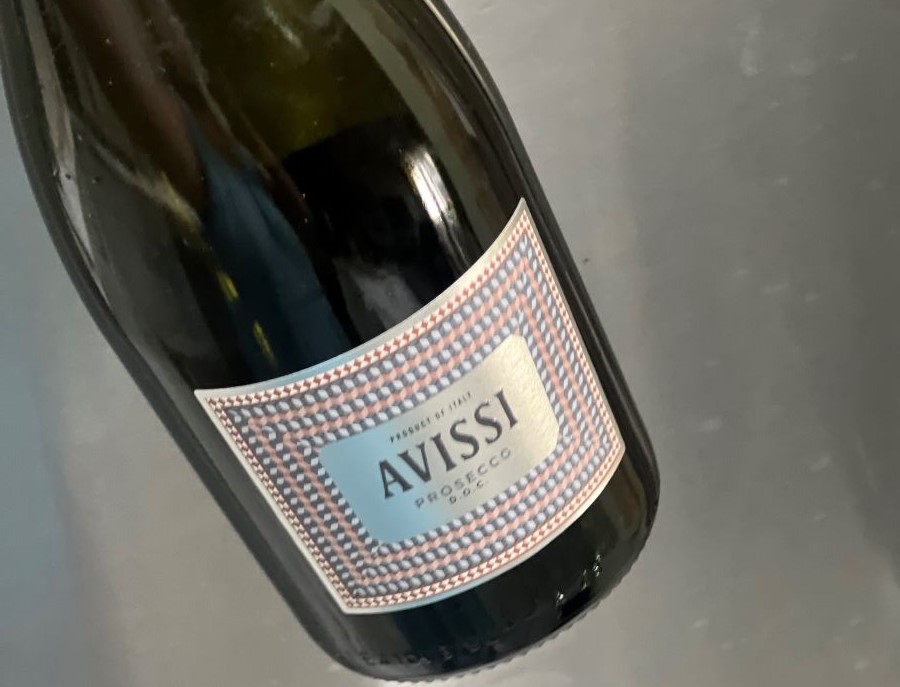 Bottle of Avissi Prosecco against a stainless steel refrigerator door, a Sparkling Wine For 4th Of July