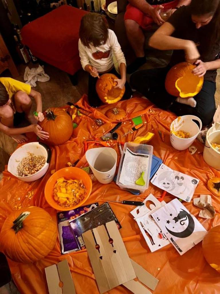 group of kids and adults sitting on the floor in a circle with pumpkins looking for Inspirations For Pumpkin Carving